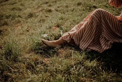 Low section of woman sitting on grass