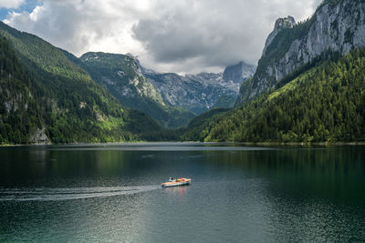 Scenic view of lake by mountains against sky