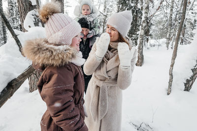 Dad with mom and two daughters having fun in the snowy forest. high quality photo