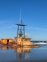 Sailboat moored on sea against sky