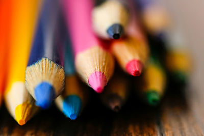 Close-up of colored pencils on wooden table