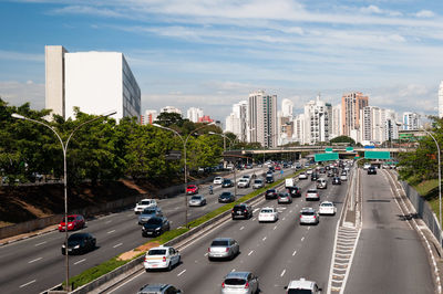 Traffic on road in city against sky