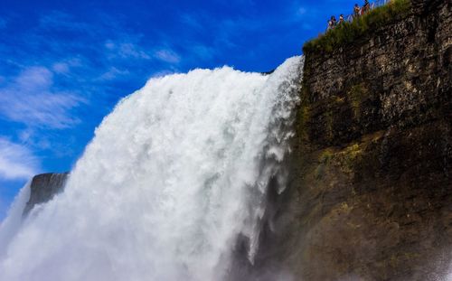 Low angle view of waterfall against sky