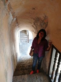 Full length of woman standing against wall