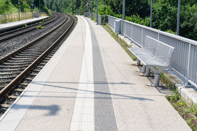 Empty railroad tracks along plants
