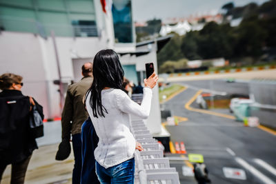 Rear view of women standing on road in city