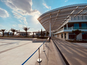 Residential and business modern seaside buildings, palm trees in distance, under clouded sky