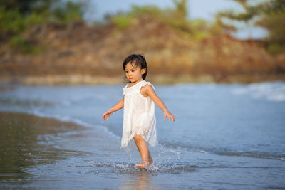 Full length of girl standing in water