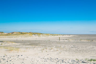 Scenic view of beach against blue sky