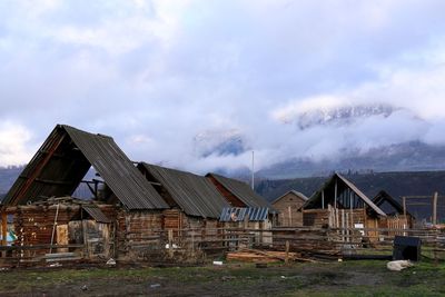 Houses by buildings against sky