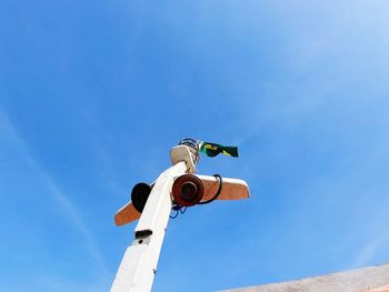 Low angle view of telephone pole against blue sky