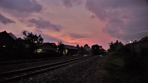 Railroad tracks against sky during sunset