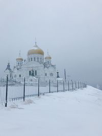 Built structure on snow covered building against sky