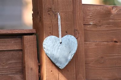 Close-up of heart shape hanging on wood