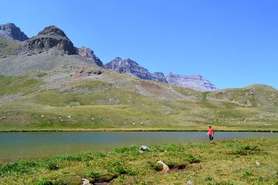 Man fishing in lake against mountains