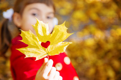 Close-up of woman holding red flower