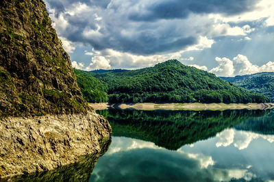 Scenic view of calm lake against cloudy sky