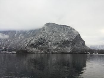 Scenic view of lake by mountains against sky
