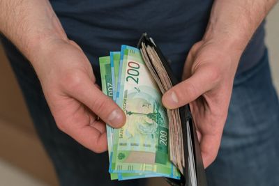 Midsection of man removing paper currency from wallet