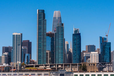 Skyscrapers in city against clear blue sky