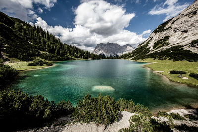 Scenic view of lake by mountains against sky