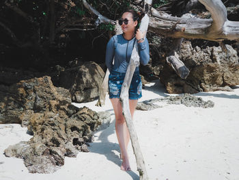 Full length of young woman standing on rock