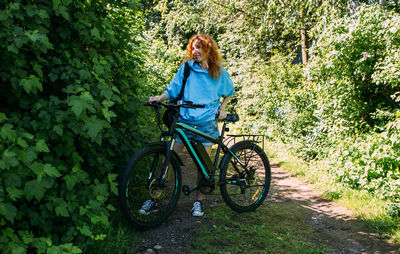 A young woman uses a modern electric bicycle for sports and outdoor recreation