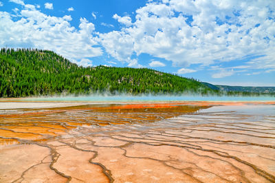 Mountain lake with geysers, red bottom, salt deposits, yellow stone nature park.