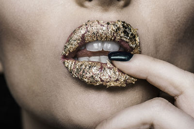 Close-up of woman wearing golden lipstick