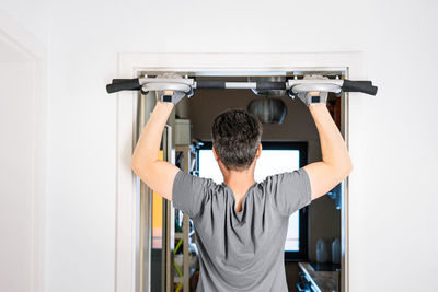 Rear view of man working out at home