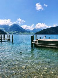 Scenic view of wooden posts in lake against sky