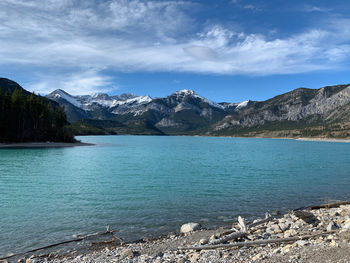 Scenic view of lake by mountains against sky