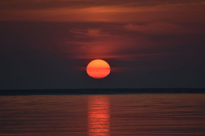 Scenic view of sea against orange sky