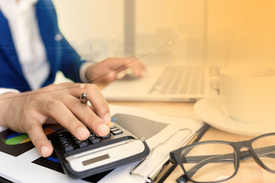 Midsection of man using laptop on table