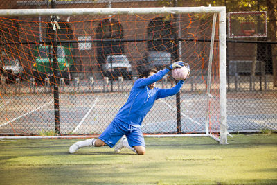 Sportsman catching ball at goal post on field