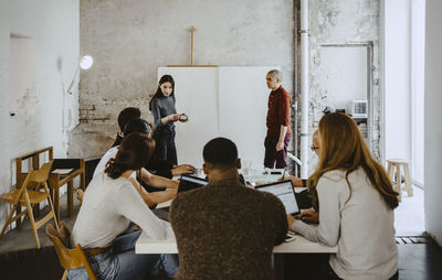 Female hacker presenting in front of colleagues at startup company