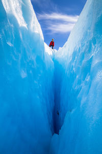 Low angle view of person standing on glacier