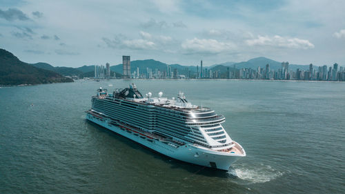 Ship in sea against sky in city