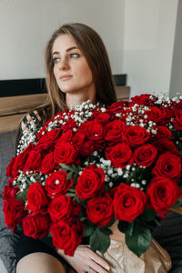 Portrait of young woman standing against wall