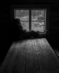 Woman sitting by window at home