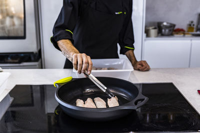 Midsection of man preparing food in kitchen at home