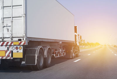 Vehicles on road against clear sky in city