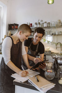 Male owner sharing tablet pc with female colleague at cafe