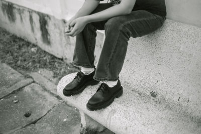 Low section of woman standing on footpath