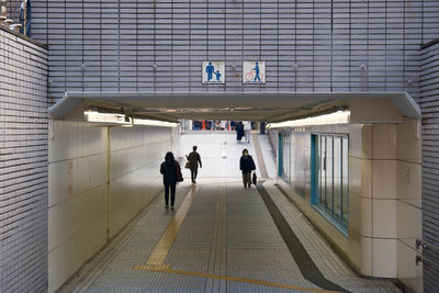 Rear view of people walking in subway