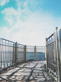 Railing by sea against sky