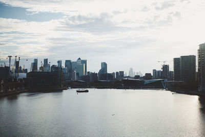 River amidst buildings in city of london against sky