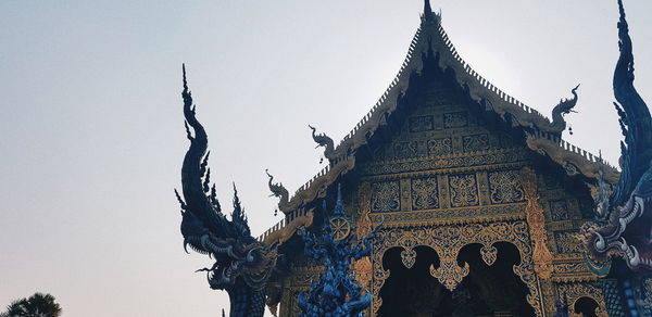 Low angle view of statues on building against sky