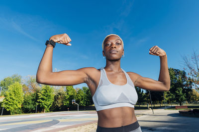 Young athlete showing biceps in sports court