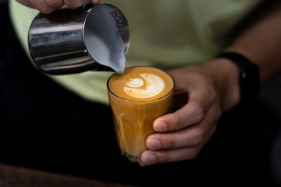 Close-up of hand holding coffee cup